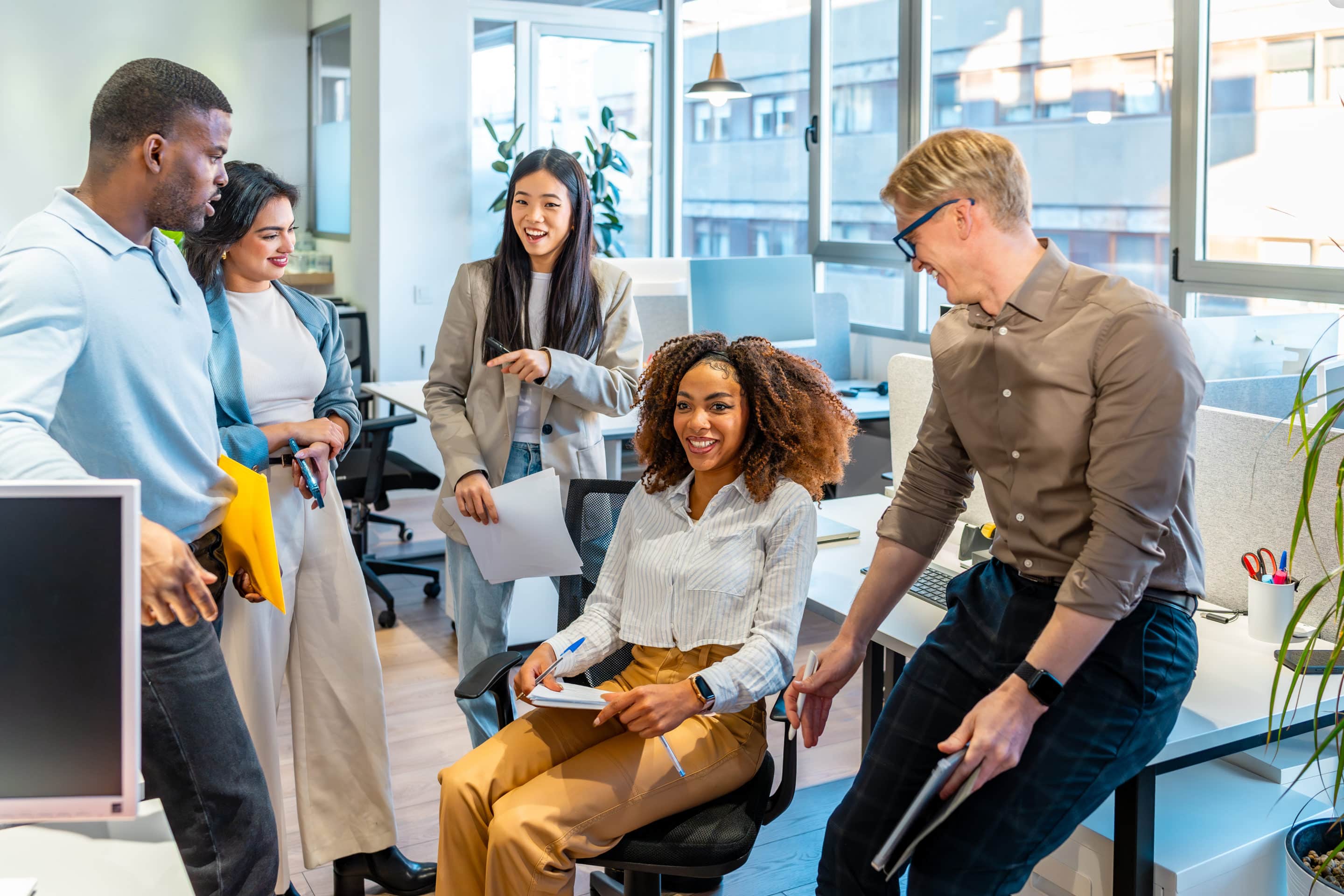 Diverse colleagues engaging in teamwork, sharing ideas, and working together in a modern coworking space