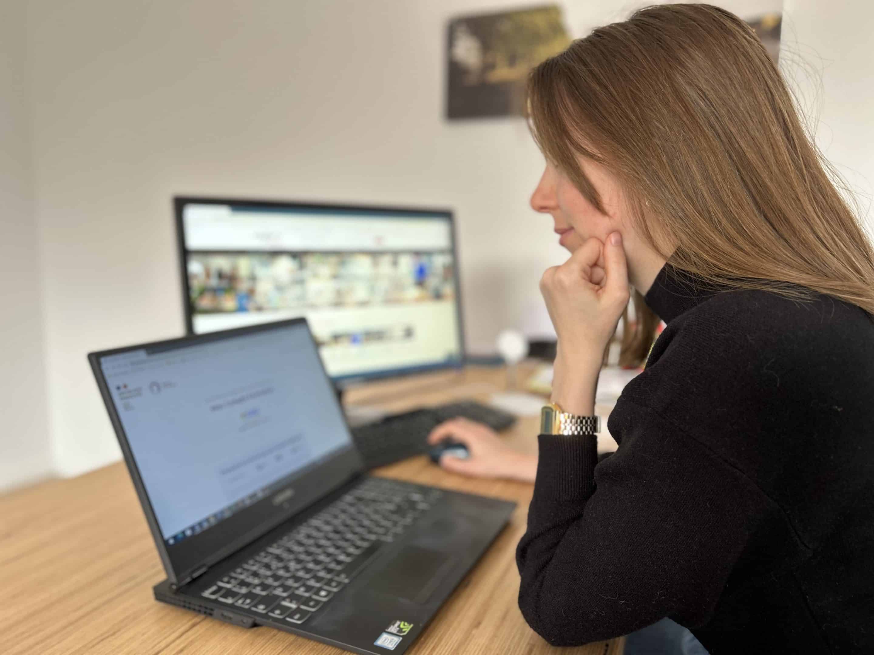 Femme utilisant ordinateur portable et écran