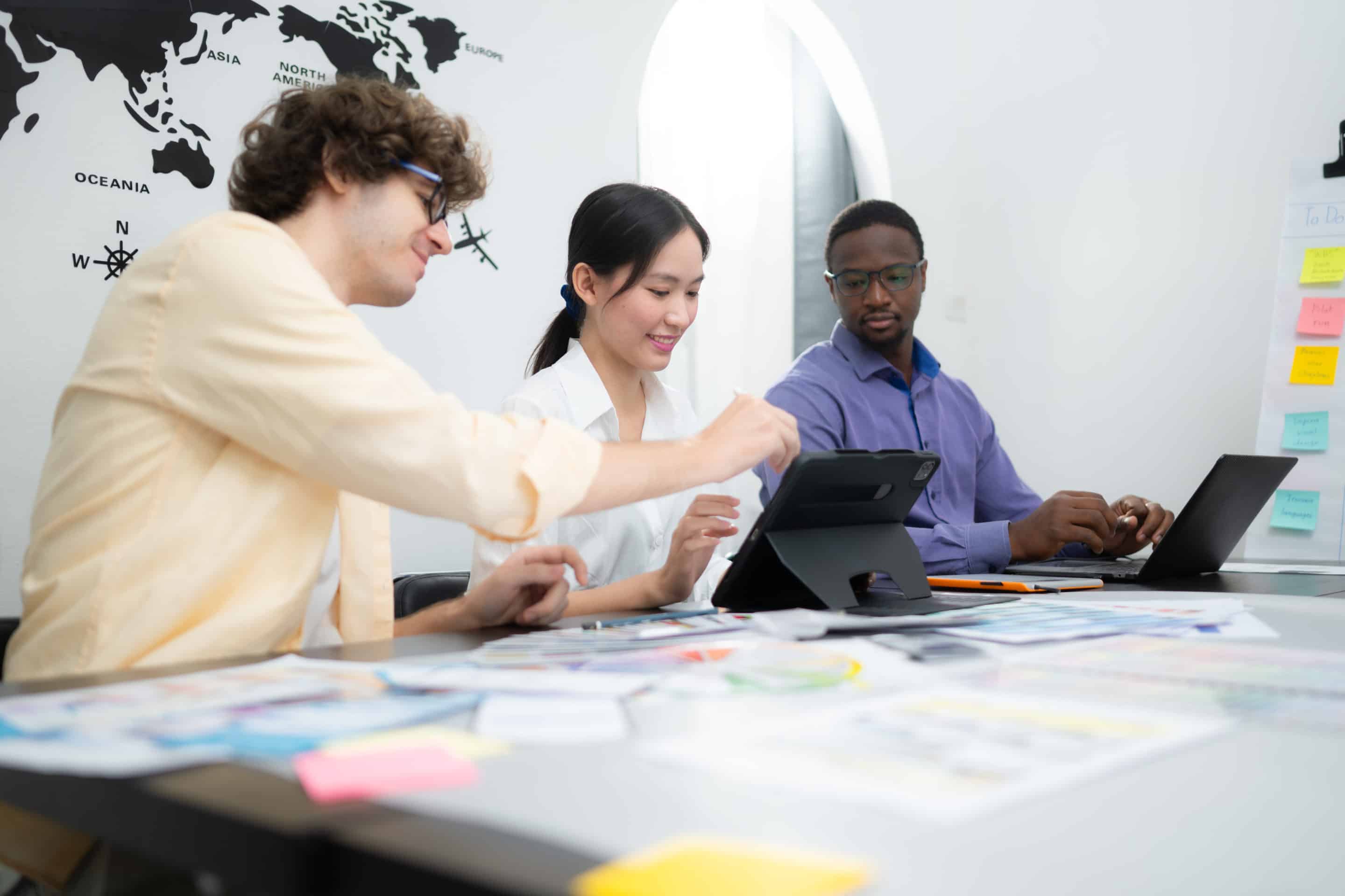 Groupe collaborant sur des tablettes et ordinateurs portables.