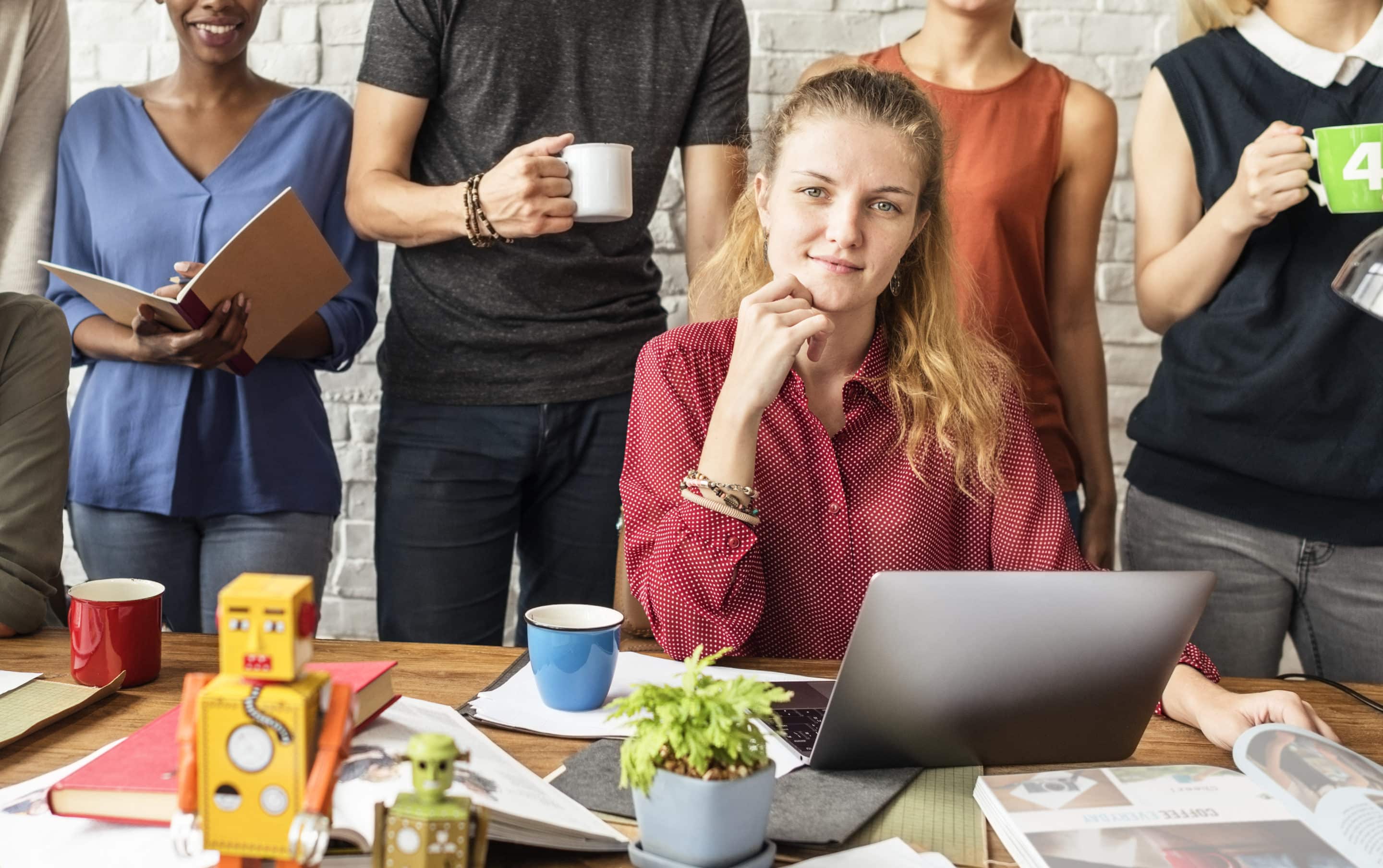 Jeune femme au bureau avec ordinateur portable.
