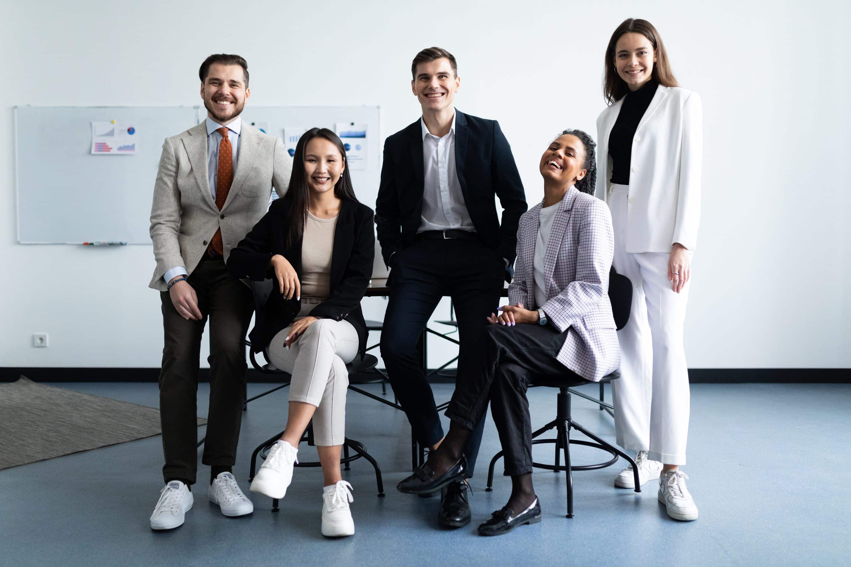 Équipe souriante posant ensemble dans un bureau.