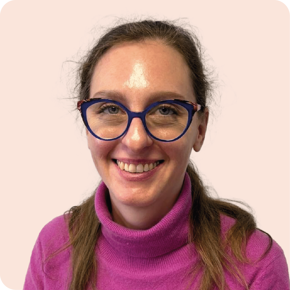 Personne souriante portant des lunettes et un pull.