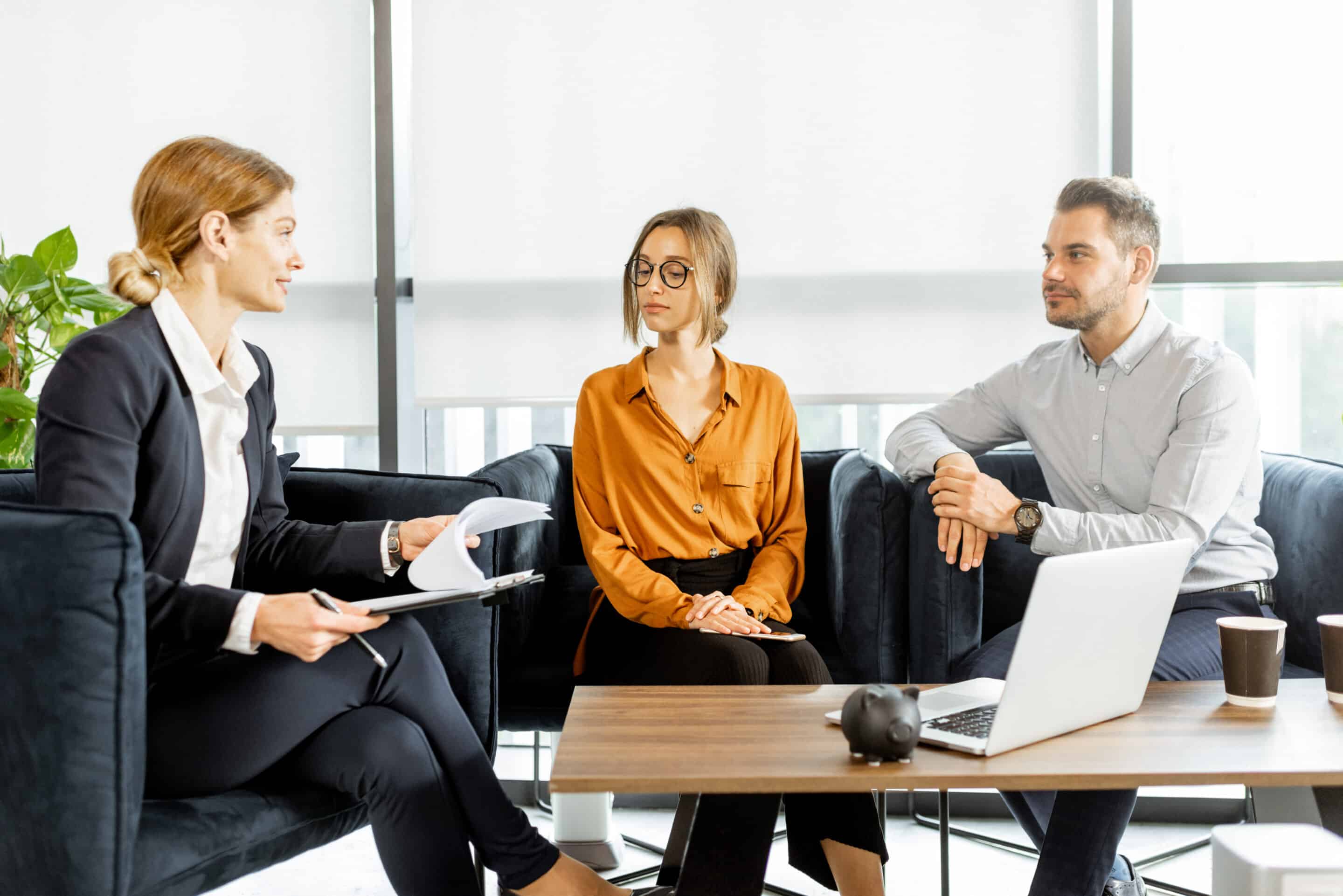 Réunion professionnelle avec trois personnes souriantes.