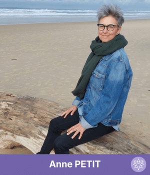 Personne souriante assise sur une plage.